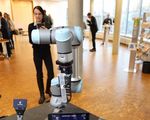 Eine Frau fotografiert einen Industrieroboter