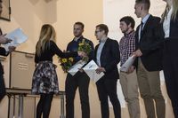 Foto: Fünf Absolventen bekommen eine Gratulation und Blumen überreicht.