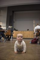 Foto: Ein Kleinkind krabbelt im Hautgang zwischen den Sitzreihen auf dem Boden.