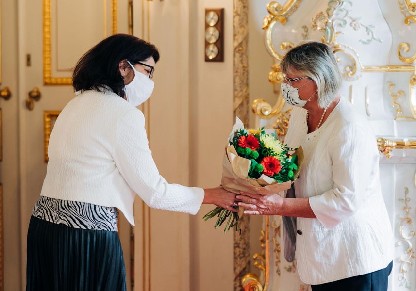 Foto: Die tschechische Vize-Kultusministerin Dana Prudíková (links) und die WHZ-Projektpartnerin der TU Liberec Helena Neumannová bei der Preisvergabe in Prag. Es wird ein Blumenstrauß überreicht. Beide tragen Gesichtsmasken. Im Hintgerund ein festlicher Raum. 