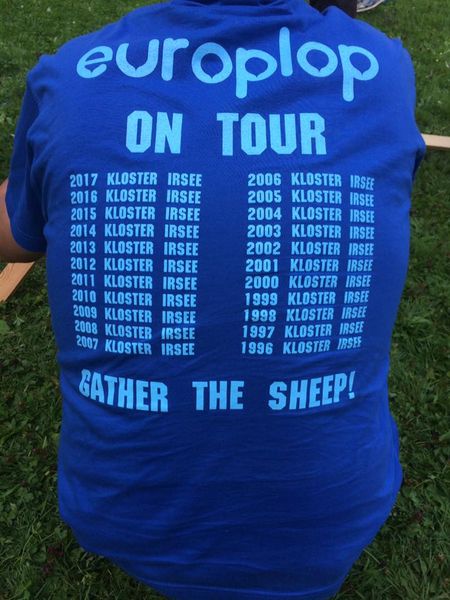 Foto: Rückenansicht einer Person. Auf dem T-Shirt sind Aufschriften mit europlop on tour und Jahreszahlen mit Kloster Irsee bedruckt.