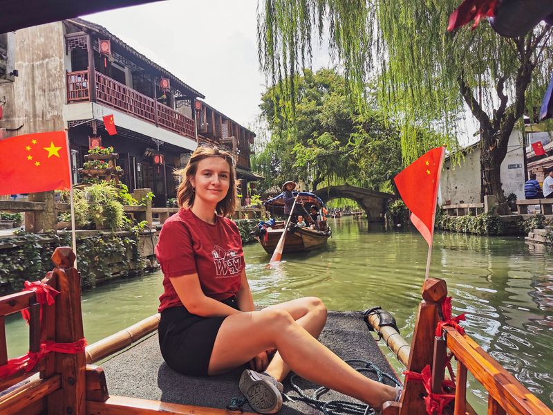 Eine Studierende im WHZ-T-Shirt befährt einen Kanal im chinesischen Suzhouu