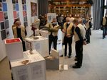 Foto: Mehrere Personen stehen zwischen Exponatenund Informationen einer Ausstellung.