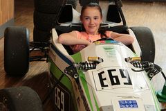 Foto: Eine Schülerin sitzt im Rennwagen des WHZ Racing Teams in der Aula Scheffelberg.