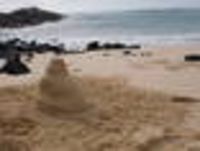 Foto: Eine Sandfigur am Strand.