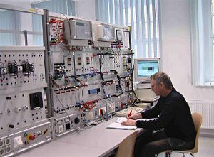 Foto: Blick in das Labor Elektrische Anlagen II mit einem sitzenden Mitarbeiter.