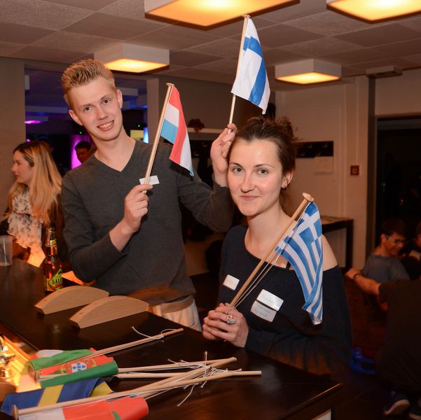 Foto: Zwei Studierende halten verschiedene Länderflaggen in den Händen.