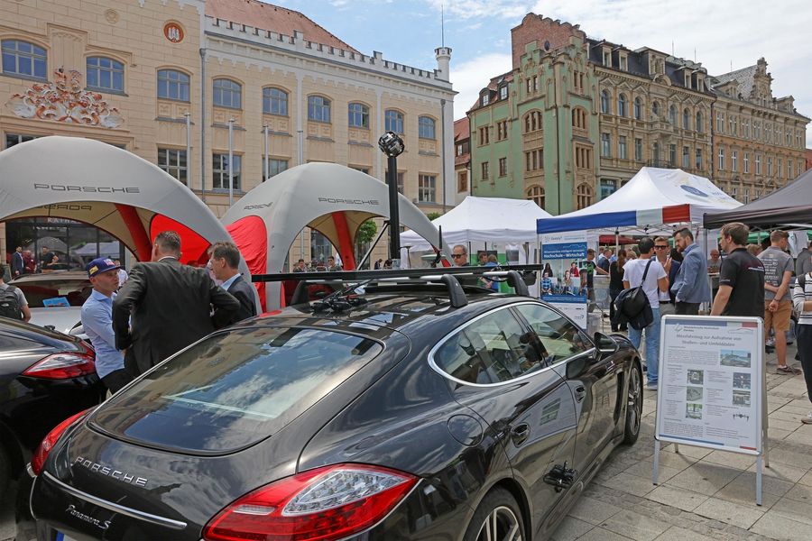 Foto: Fahrzeuge und Pavillons mit Besuchern auf dem Hauptmarkt.