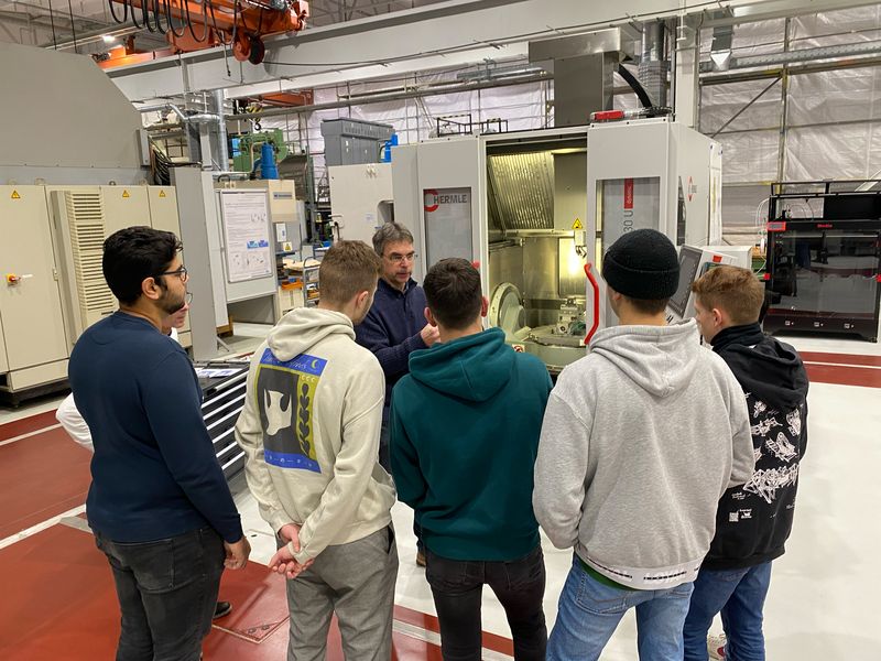 Ein Laboringenieur führt eine Gruppe von Schülern durch die Laborhallen der Fakultät Automobil- und Maschinenbau der WHZ. 