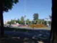 Foto: Blick auf einen Kreuzungsbereich mit einem Kreisverkehr und Springbrunnen.