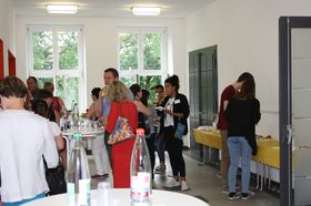 Foto: Studierende im Foyer der Aula Scheffelberg bei Kaffee, Wasser und Kuchen.