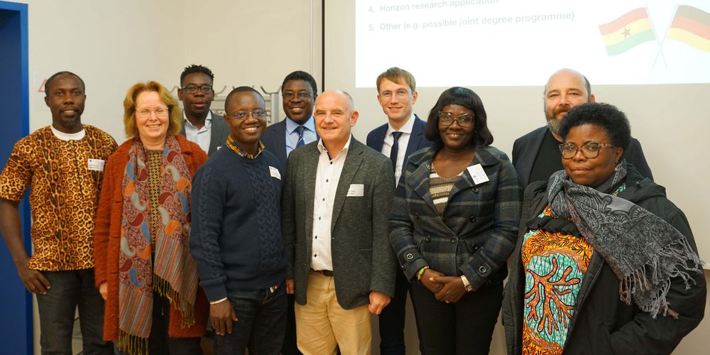 Professoren und Forscher aus Deutschland und Ghana stehen als Gruppe zusammen und schauen in die Kamera