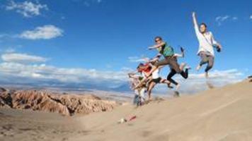 Foto 1: Studierende springen auf einer Bergsanddüne in die Luft.