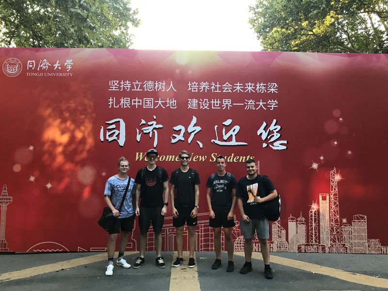 Gruppenfoto: Fünf Studierende stehen vor einem großen "Welcome New Students" Plakat der Tongji University in China.