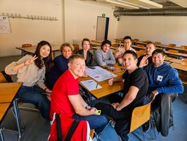 Foto: Teilnehmende am Deutsch-Intensivkurs sitzen an einem Tisch und führen eine Gruppenarbeit durch