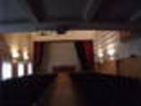 Foto: Blick in einen Saal mit Bühne.