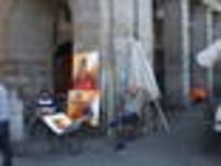 Foto: Zwei Straßenmaler sitzen und warten auf Kundschaft.