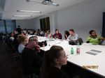 Foto: Blick in einen Konferenzraum. Studierende sitzen an einem Konferenztisch und führen ein Meeting.