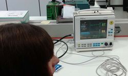 Foto: Eine Schülerin beobachtet einen Monitor mit Messwerten in einem Biomedizinlabor.