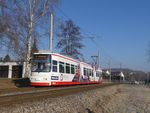 Frontansicht auf fahrende Straßenbahn vor blauen Himmel