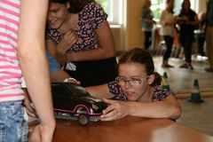 Foto: Eine Schülerin hebt die Abdeckung ihres Modellautos an, welches auf einem Tisch steht.