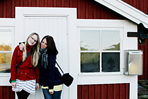 Foto: 2 Mädchen posieren vor einem Hütteneingang. Double Degree Fashion Design