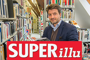 Foto: Prof. Dr. Thomas Pöpper in der Bibliothek ein Buch studierend.