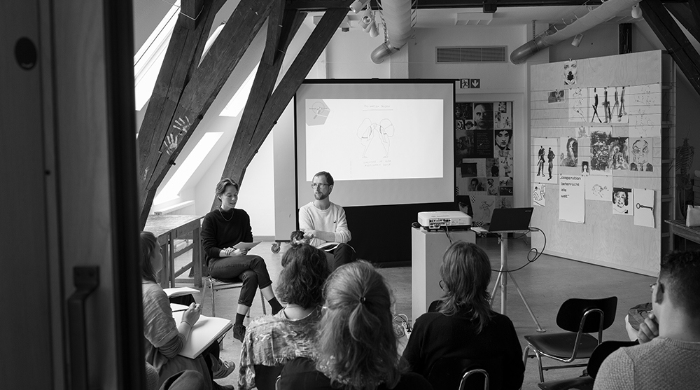 Foto: Symposium "ost in space", Teilnehmer hören zwei rednern zu, Schwarz-Weiß-Fotografie (Fotoquelle: Lars Preisser)