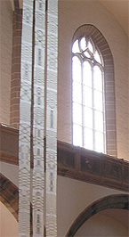 Foto: Drei Stoffbahnen hängen in einer Kirche von der Decke. Anja Bach - Das Leporello – textile Objekte für den Raum