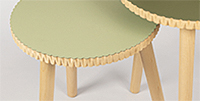 Foto: zwei hölzerne Tische mit grünem Bezug auf Deckfläche