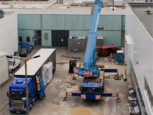 Foto: Luftbild. Ein LKW und ein Kran stehen vor der Laborhalle Rasmussenbau.