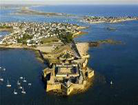 Foto 2: Luftbild auf eine Landspitze im Meer. Darauf ist eine Festungsanlage zu sehen.