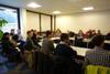 Foto: Exkursion zur Firma SiCrystal AG in Nürnberg. Teilnehmer sitzen in einem Seminarraum.