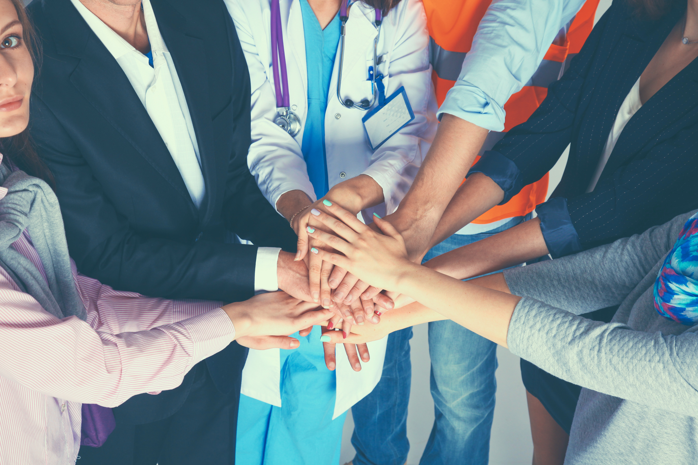 Titelfoto: Fachgruppe Management. Eine Gruppe Personen legt ihre Hände übereinander.