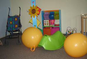 Foto: Ein kleiner Ausschnitt vom Kinderbetreuungsraum ist zu sehen. Es steht verschiedenes Spielzeug im Raum.