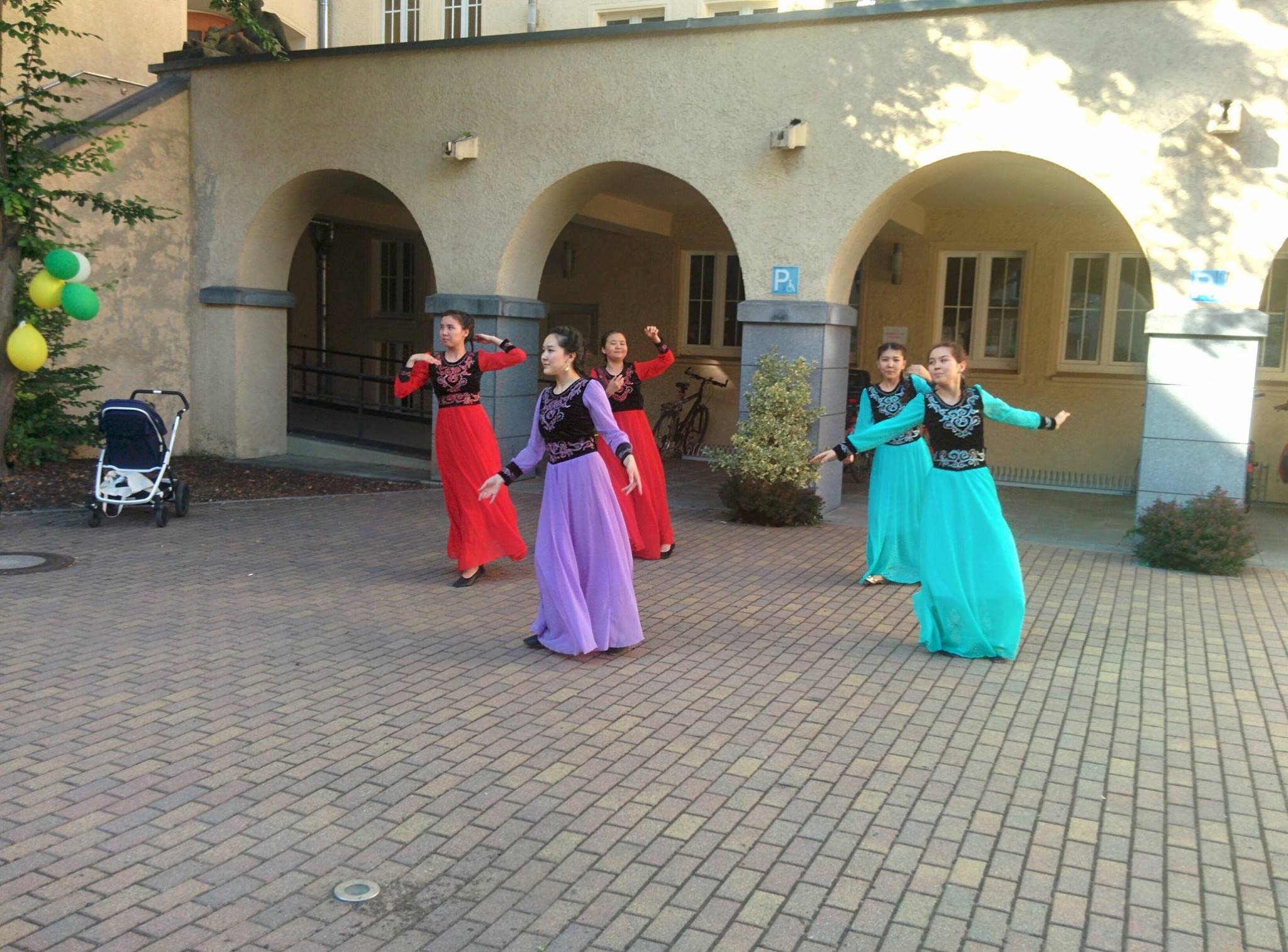 Foto: Fünf Tänzerinnen einer Folklore Gruppe tanzen im Bibliotheks Innenhof.