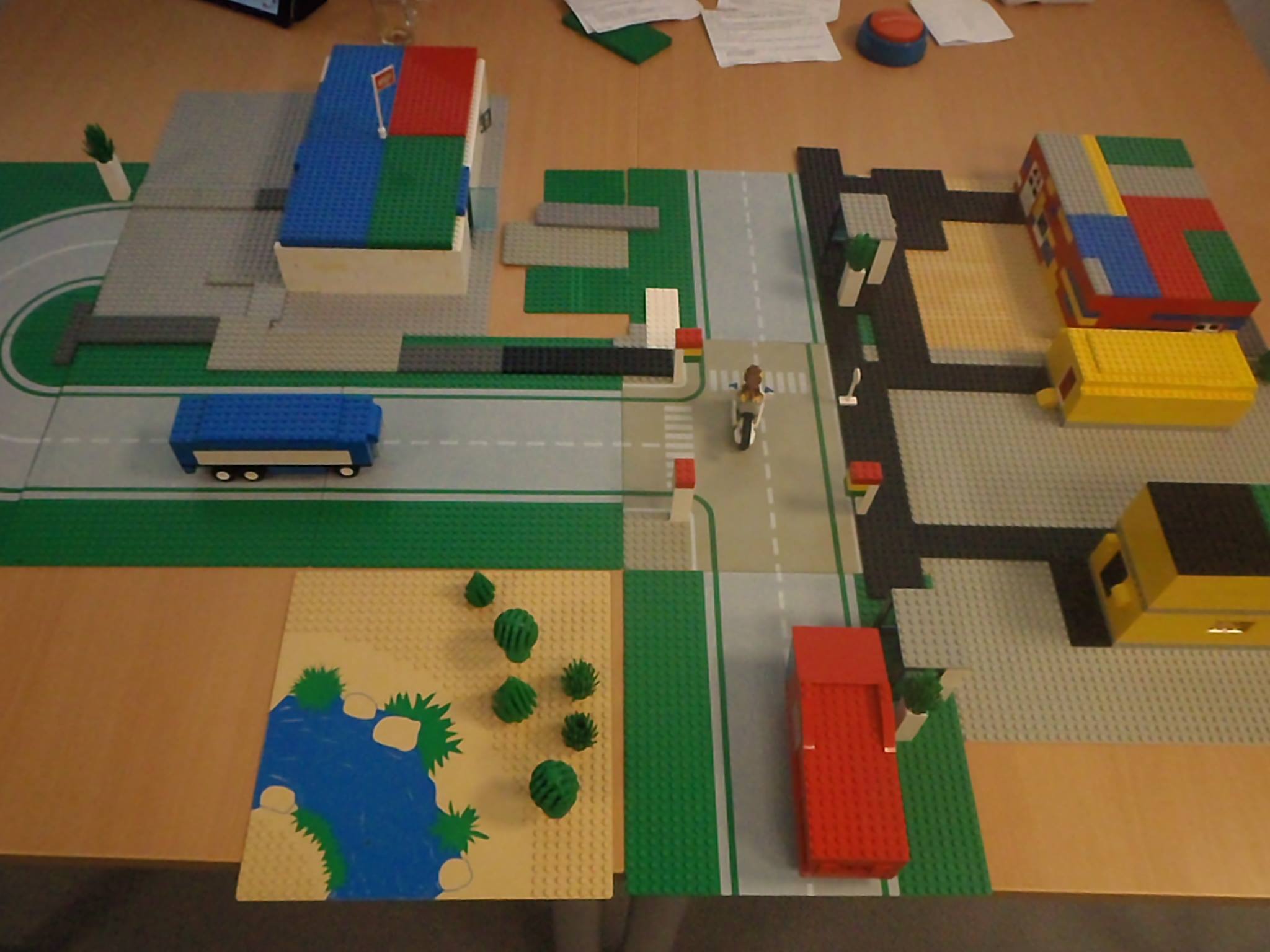 Foto: Auf einem Tisch stehen Grundplatten mit Straßen, Gebäuden und Fahrzeugen aus Lego.