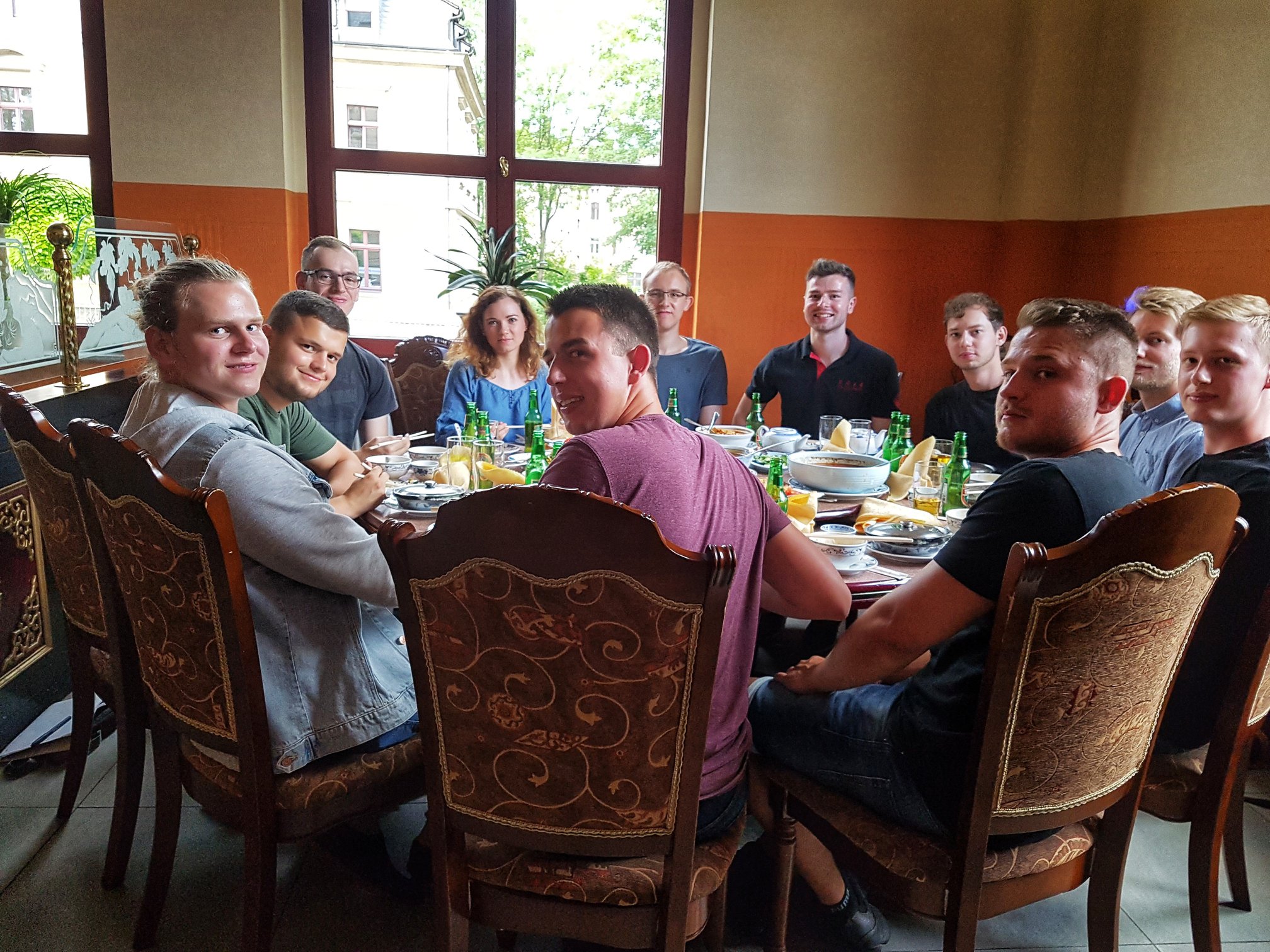 Foto: Studierende sitzen in einem chinesischen Restaurant an einem großen runden Tisch mit Speisen und Getränken.