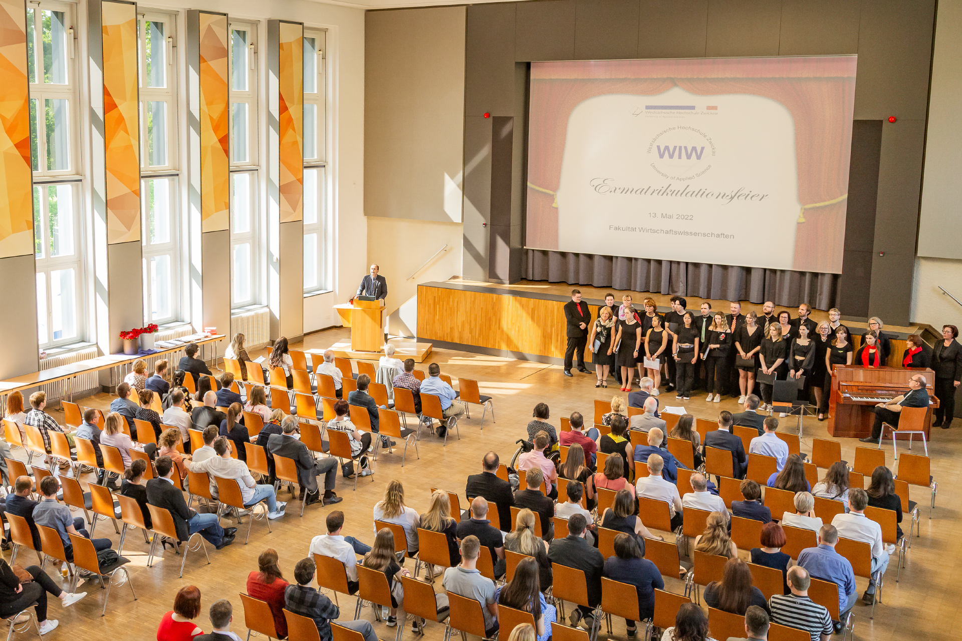 Foto: Exmatrikulationsfeier Fakultät WIW in der Aula Campus Scheffelberg, Absolventen vor der Bühne, im Publikum Angehörige