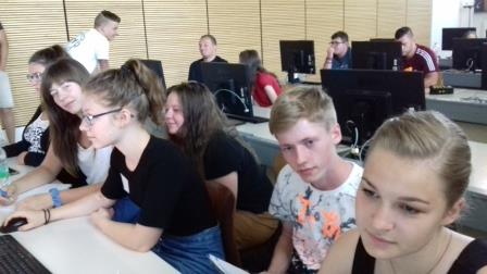 Foto: Studierende sitzen in einem Computerpool und bearbeiten ihre Aufgaben.