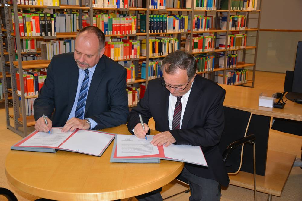 Andreas Fleischer und Prof. Gunter Krautheim unterzeichnen den Kooperationsvertrag.