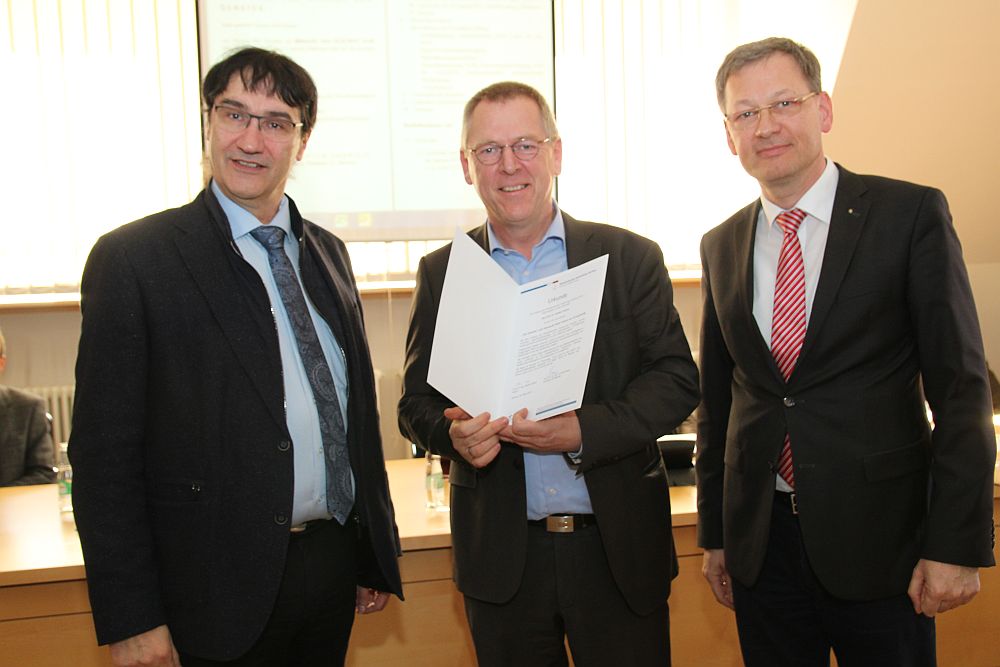 Gruppenfoto: 3 Personen. Übergabe des Lehrpreises durch Rektor Prof. Kassel.