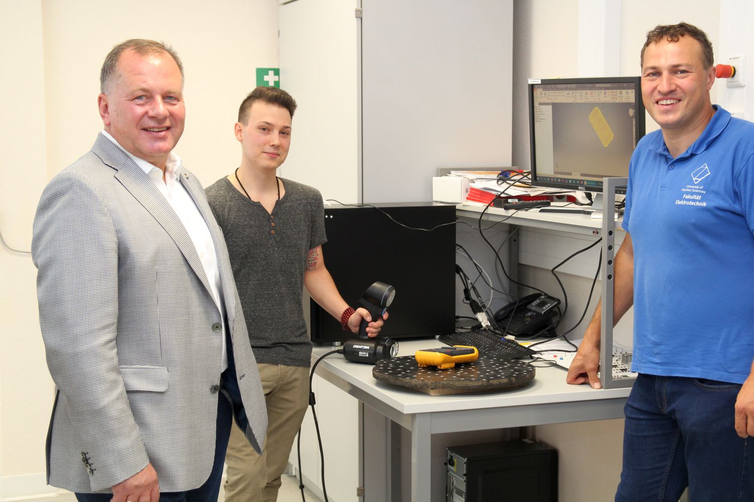 Foto: Jens Hertwig, Norman Brauns und Prof. Rigo Herold stehen vor einem Laborarbeitsplatz der Fakultät Elektrotechnik. Der Student Norman Brauns steht in der Mitte und hält einen 3D-Scanner in der Hand. | Quelle: WHZ