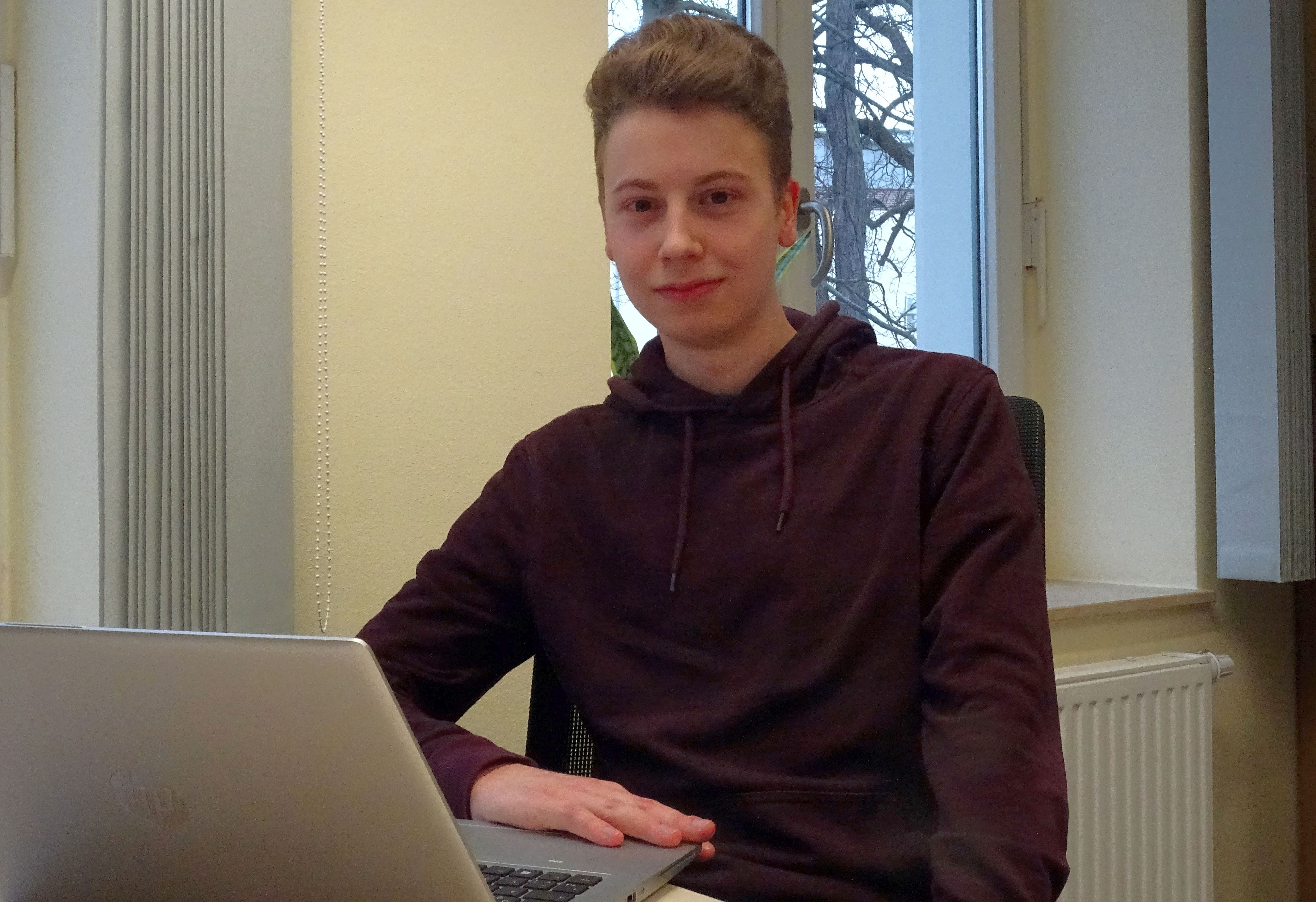 Foto: Der Student Alexander Päßler sitzt hinter vor einem Laptop