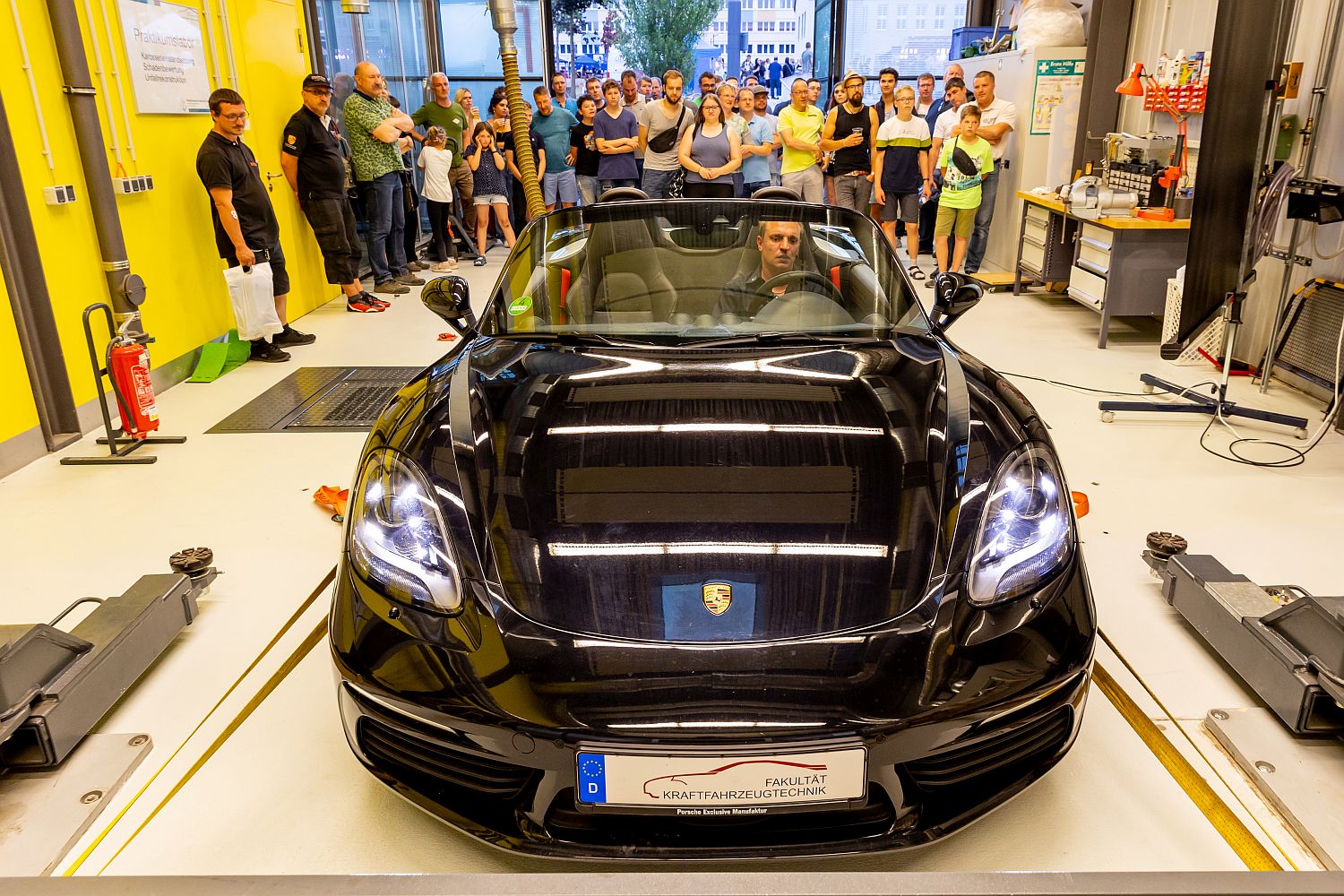 Foto: Personen in einem Laborbereich an einer automobiltechnischen Prüfanlage auf der ein Porsche steht (Foto: Helge Gerischer)