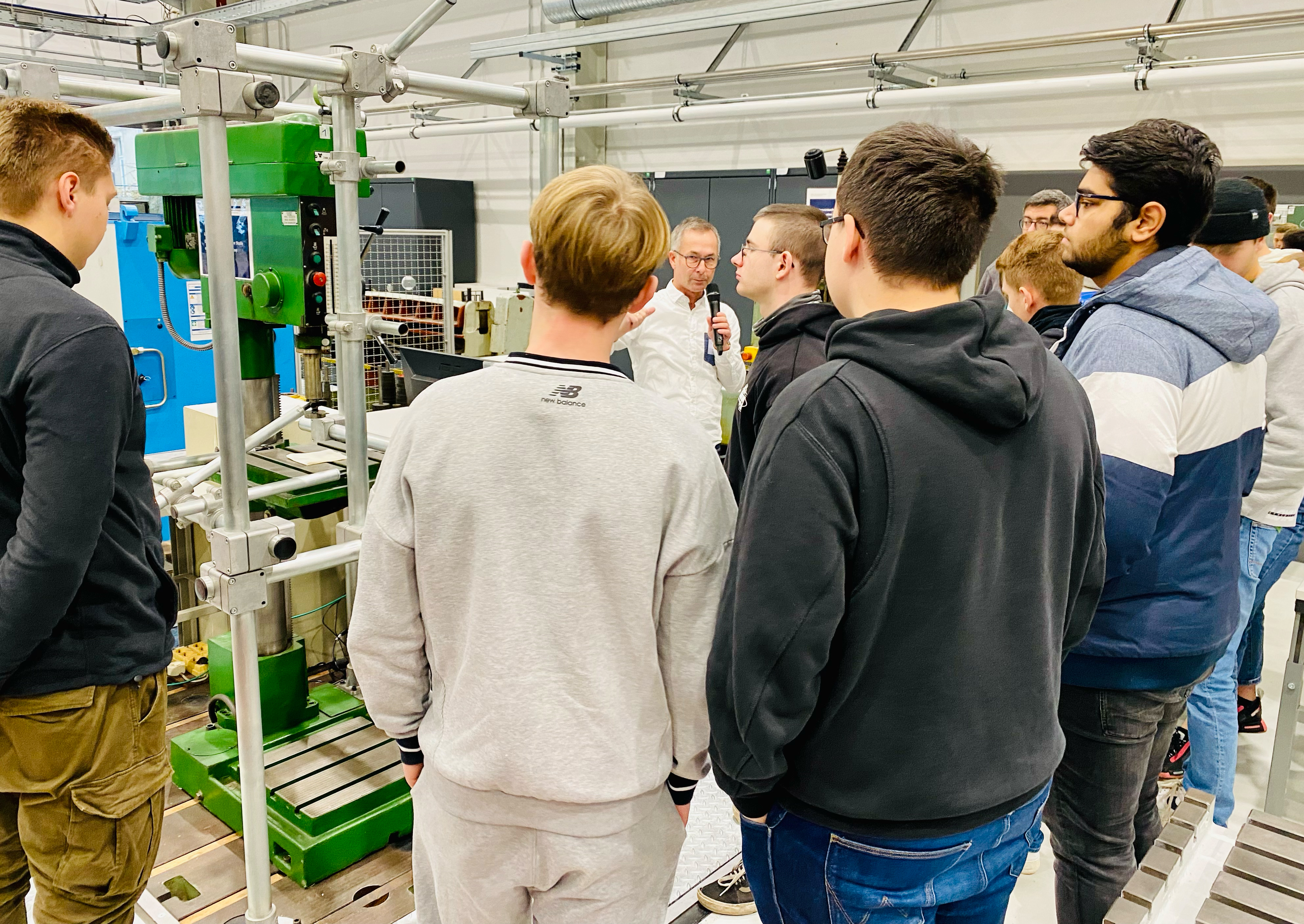 Ein Laboringenieur führt eine Gruppe von Schülern durch die Laborhallen der Fakultät Automobil- und Maschinenbau der WHZ. 