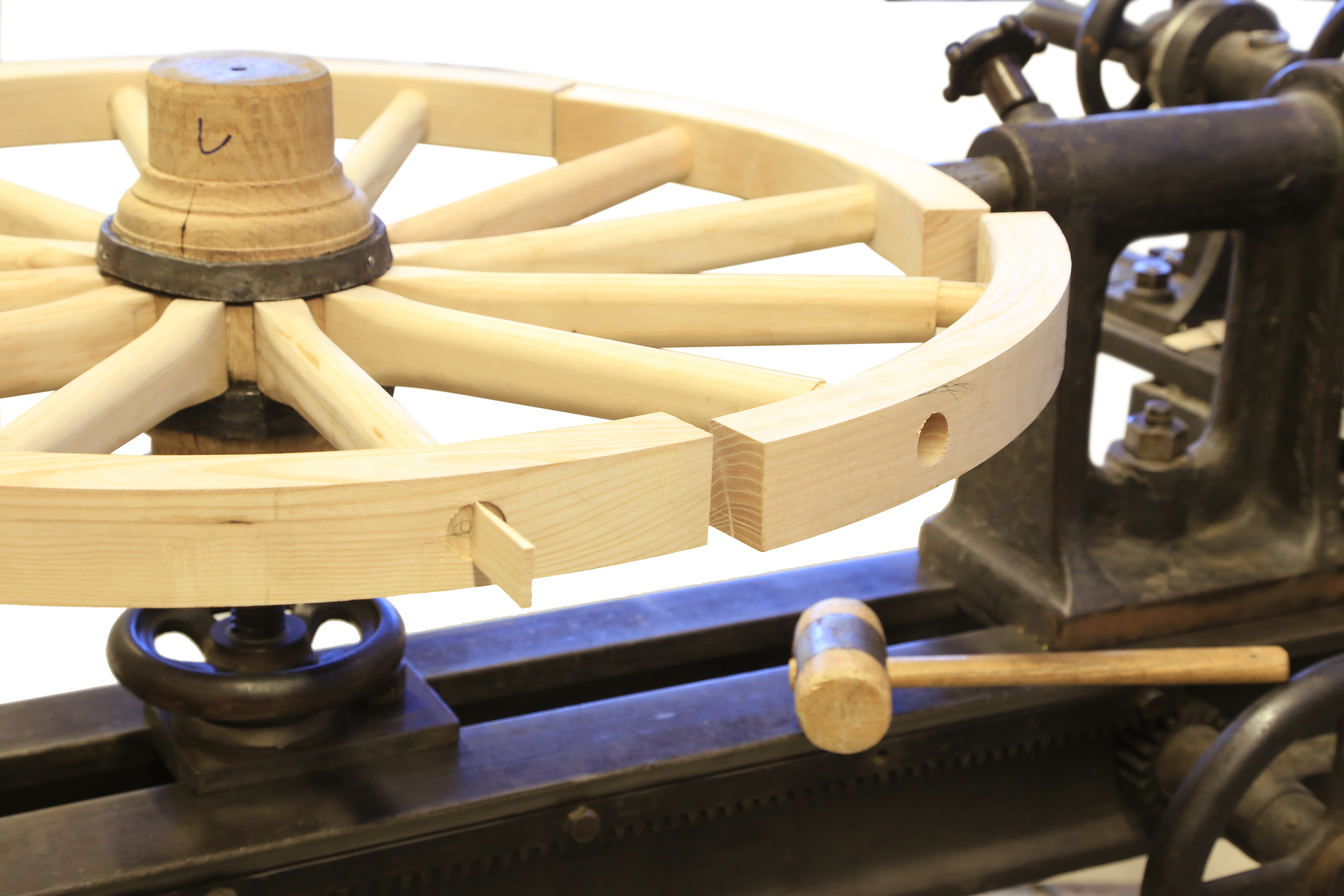 Foto: Maschinenbau-Student entwickelt Ponykutsche im viktorianischen Stil, ein Holzrad in einem Werkzeug eingespannt (Quelle: Till Kliche) 