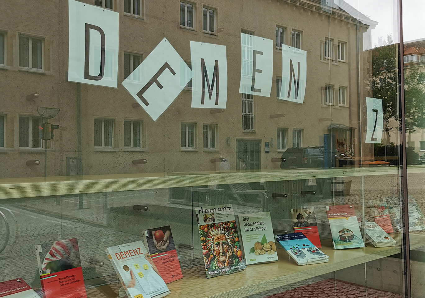 Schaufenster einer Bibliothek mit Büchern zum Thema Demenz und Plakaten mit der Aufschrift Demzenz zu Werbezwecken